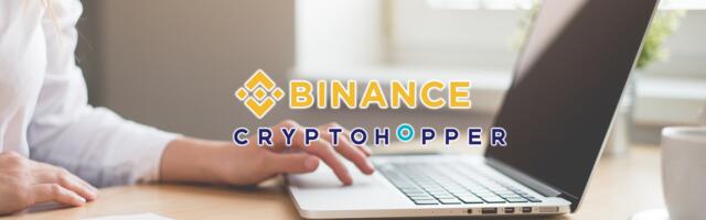 De logo's van Binance en Cryptohopper met op de achtergrond een laptop die door een vrouw wordt bediend.