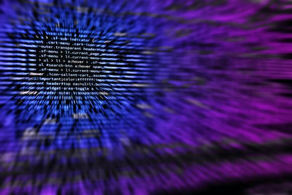 Computer codes, gecombineerd met paarse en blauwe effecten.