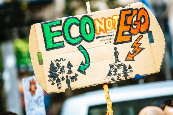 Protestbord met de tekst 'Eco, not ego'
