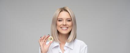 Een jonge vrouw met een Bitcoin in haar hand