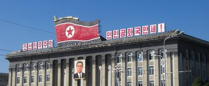 Noord-Koreaans gebouw met vlag en president